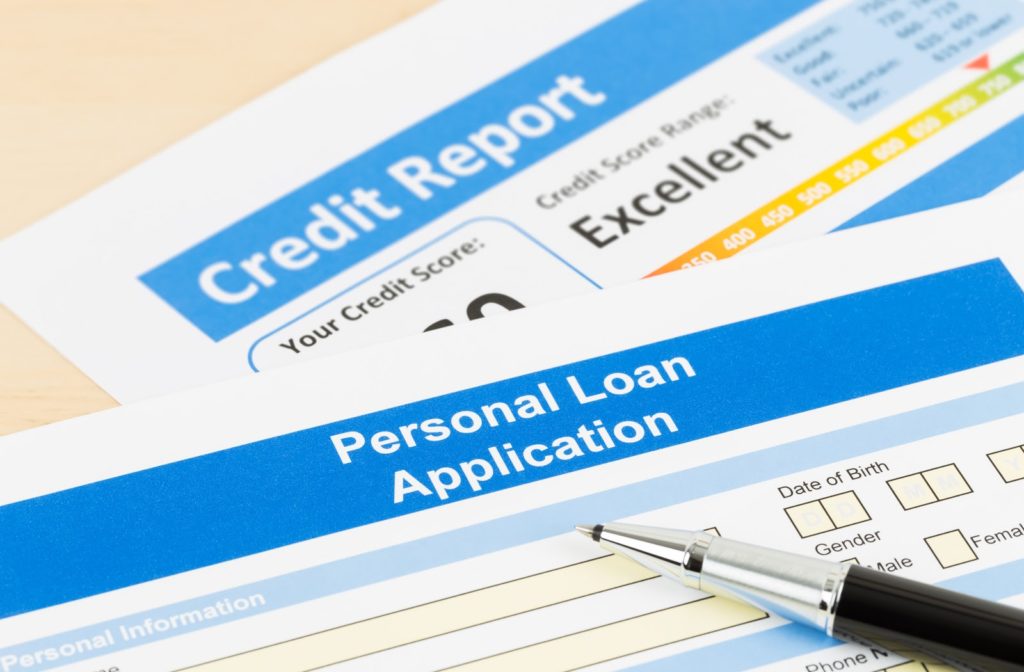 Pen lying on personal loan application next to credit check printout
