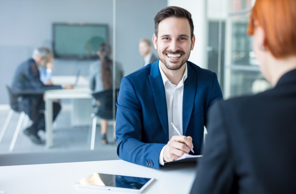 Happy man sitting after signing his loan application with financial professional