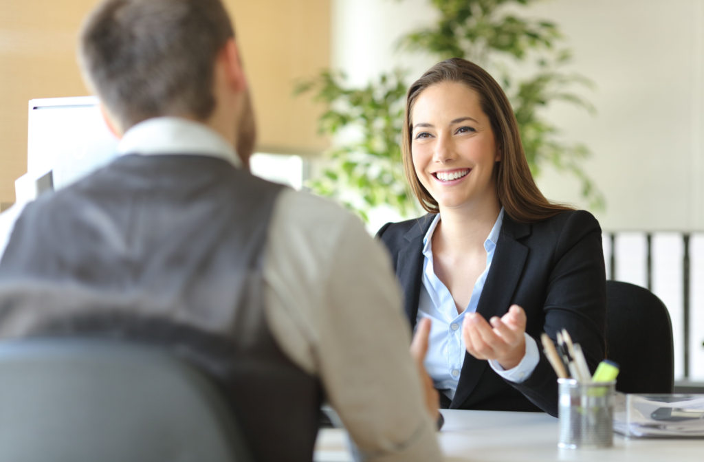 A man talking and asking financial advice from a female loan officer