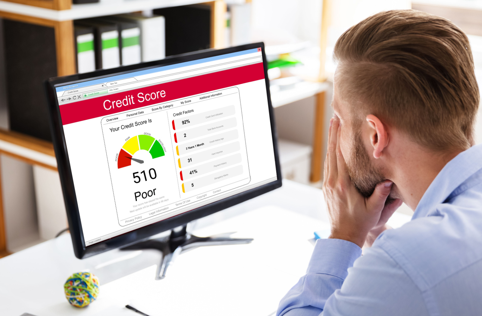 A man looking at his low credit score of 510 on a computer screen.