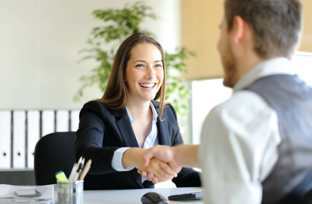 A man talking, shaking hands and asking financial advice from a female loan officer
