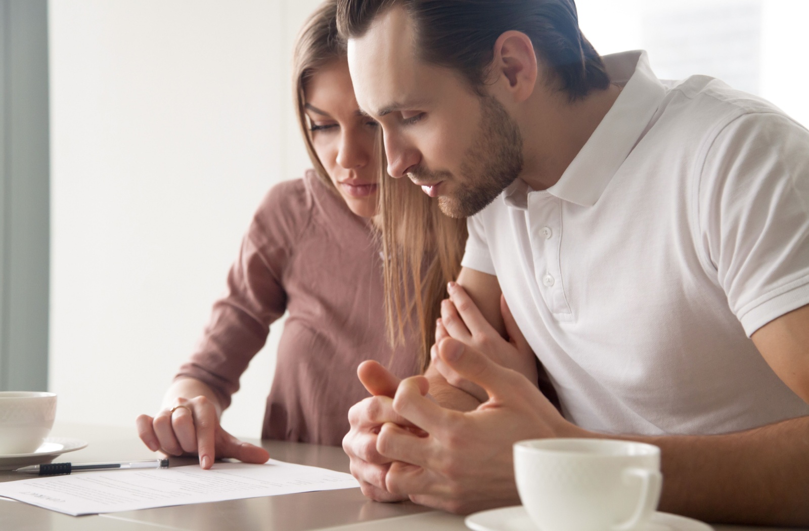 A couple sitting at the table, looking at the loan application checklist