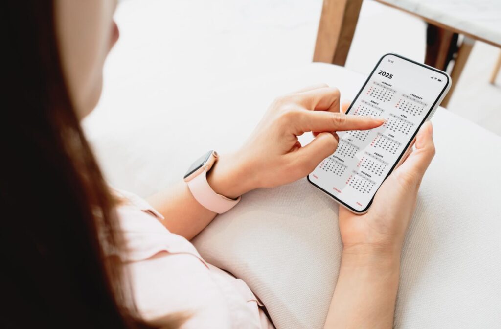A person looking at the 2025 calendar on their smart phone to plan out monthly line of credit payments.