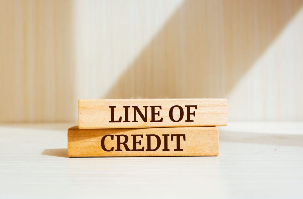Line of Credit spelled out on two stacked wooden blocks in all capitals black font.